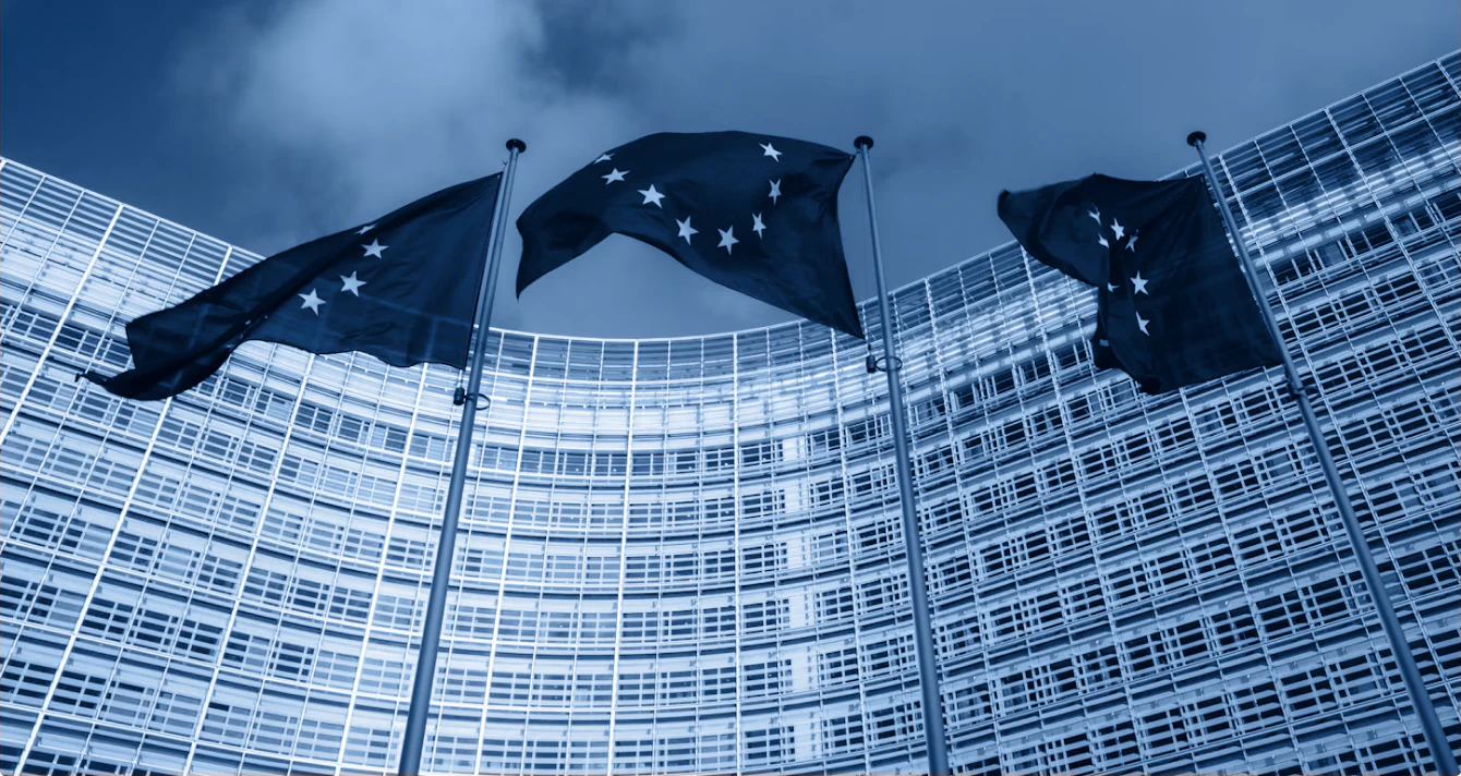 Three European Union flags flying outside the European Union building in Brussels